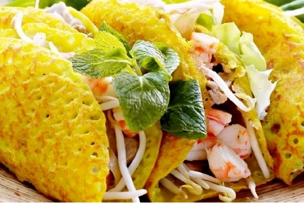 Bánh xèo miền Bắc giòn rụm ăn kèm với các loại rau thơm và nước mắm chua ngọt