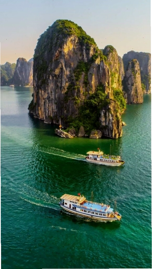 Du thuyền nhỏ giữa vịnh biển xanh và núi đá